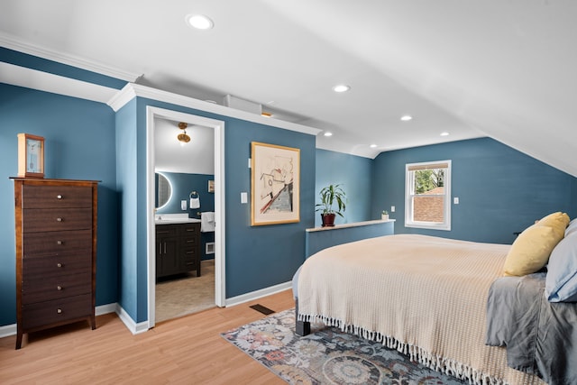 bedroom with light wood-type flooring, baseboards, ensuite bathroom, and lofted ceiling