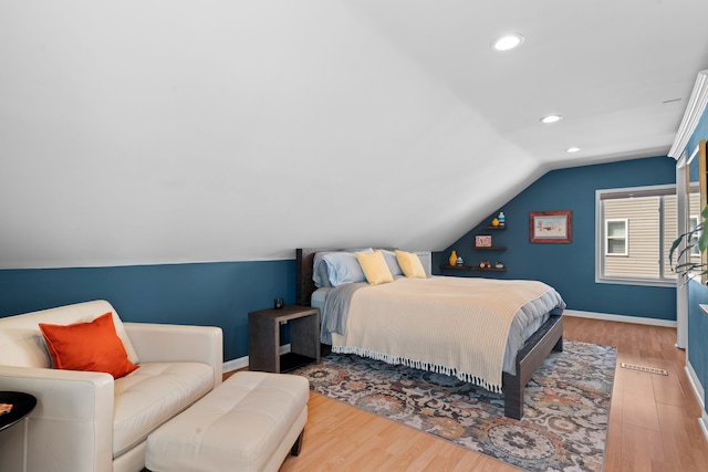 bedroom with baseboards, wood finished floors, and lofted ceiling