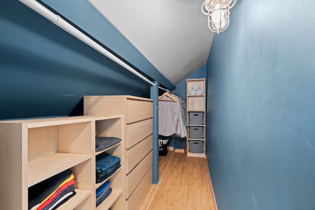 walk in closet with wood finished floors and lofted ceiling