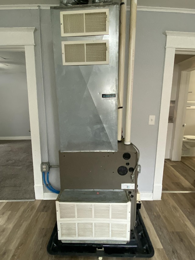 details with crown molding, baseboards, heating unit, and wood finished floors
