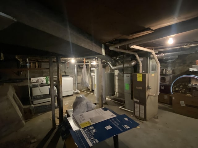 unfinished basement with heating unit and washer / dryer