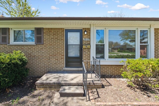 view of exterior entry with brick siding