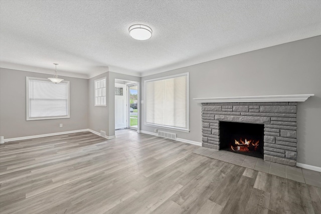 9119 Seminole, Redford, MI 48239 - unfurnished living room with a fireplace, a textured ceiling, baseboards, wood finished floors, and visible vents