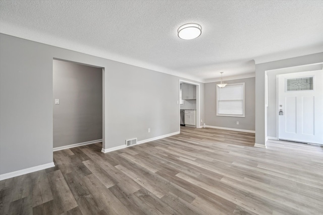9119 Seminole, Redford, MI 48239 - unfurnished living room featuring baseboards, a textured ceiling, visible vents, and light wood-style flooring