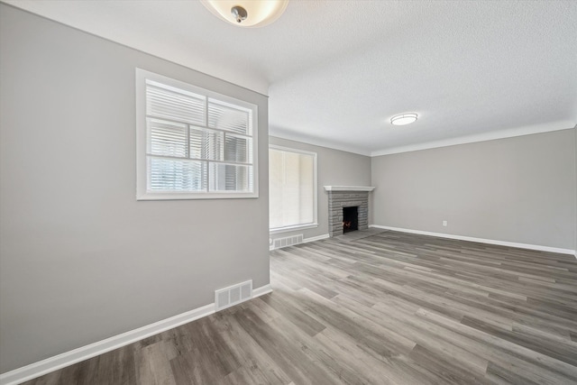9119 Seminole, Redford, MI 48239 - unfurnished living room with a fireplace, a textured ceiling, baseboards, wood finished floors, and visible vents