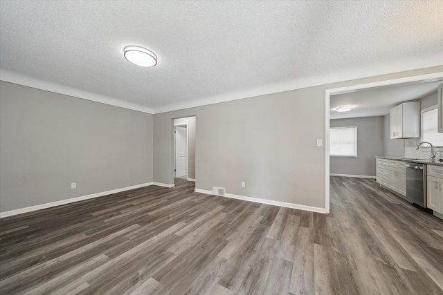 9119 Seminole, Redford, MI 48239 - unfurnished living room with visible vents, dark wood-style flooring, baseboards, a textured ceiling, and a sink