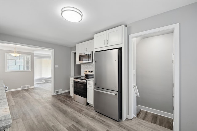 9119 Seminole, Redford, MI 48239 - kitchen with white cabinets, stainless steel appliances, visible vents, and light wood-style flooring
