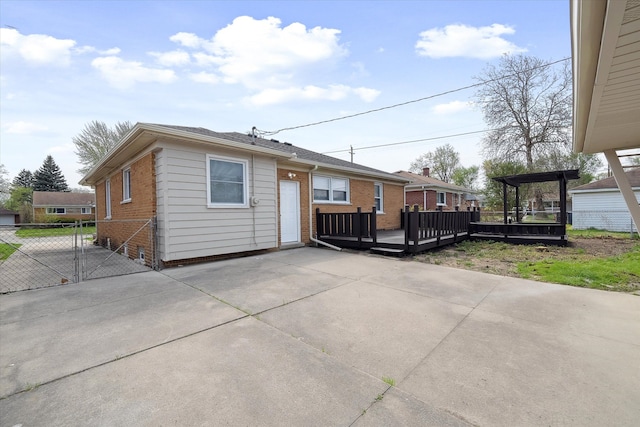 9119 Seminole, Redford, MI 48239 - exterior space with fence, brick siding, a wooden deck, concrete driveway, and a patio area