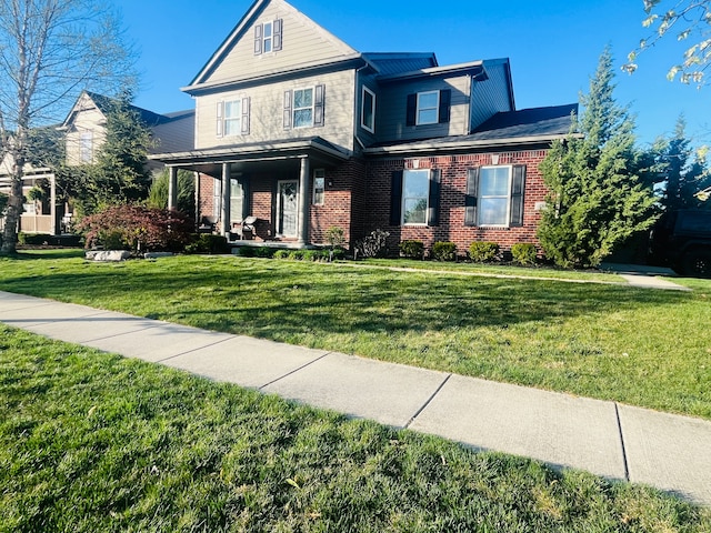 view of front of house featuring a front yard, a porch, and brick siding