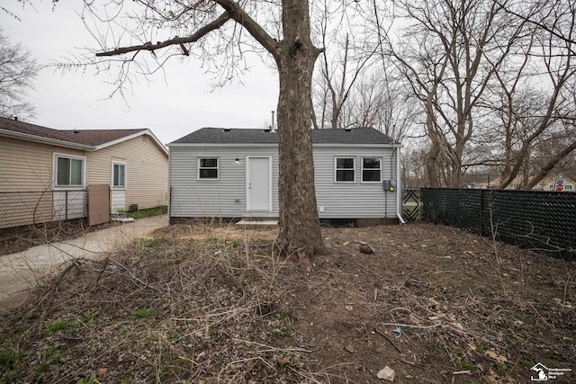 rear view of property featuring fence