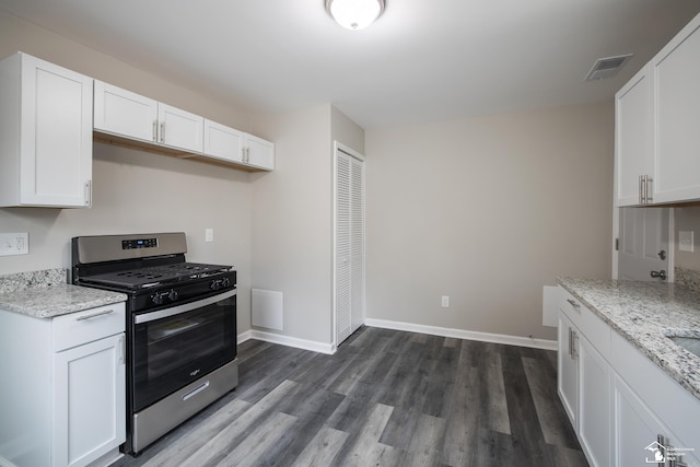 kitchen with white cabinetry, light stone countertops, dark wood finished floors, and stainless steel gas range oven