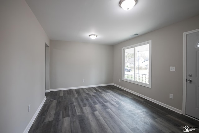 interior space with baseboards, dark wood finished floors, and visible vents