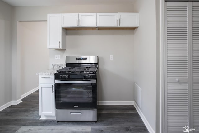 kitchen with baseboards, white cabinets, dark wood finished floors, and gas range