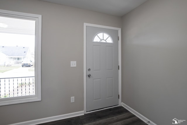 foyer featuring baseboards and dark wood-style floors