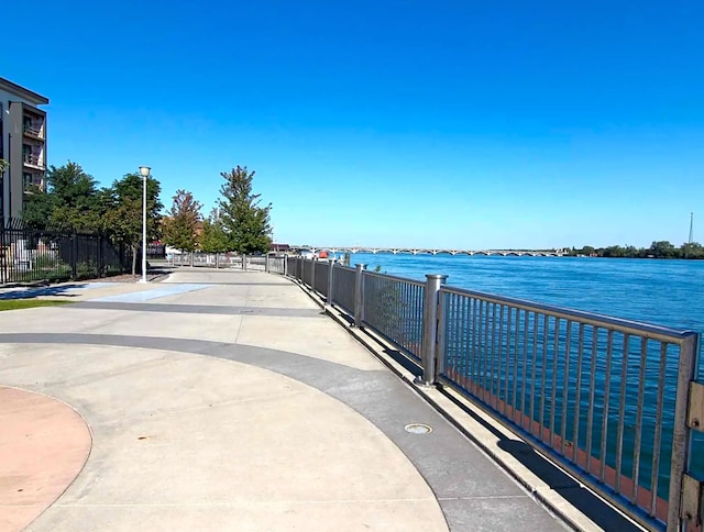 view of community featuring a water view and fence