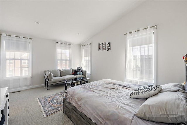 carpeted bedroom with baseboards, visible vents, and vaulted ceiling