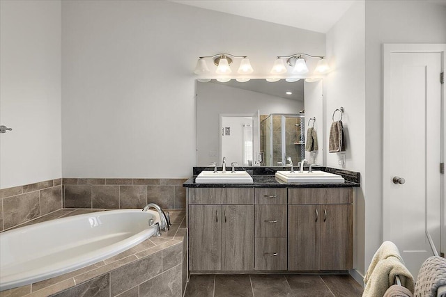 bathroom with double vanity, a bath, a sink, and a stall shower