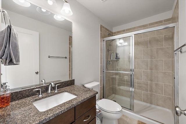 bathroom with vanity, a stall shower, and toilet