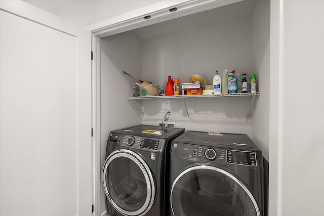 clothes washing area featuring washer and dryer and laundry area