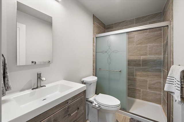 bathroom with vanity, a stall shower, and toilet