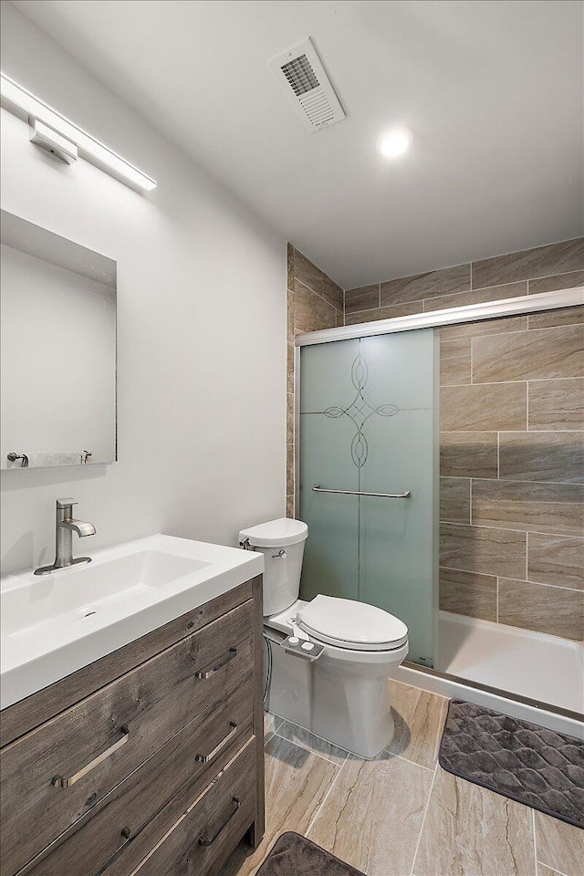 full bath with vanity, a shower stall, toilet, and visible vents