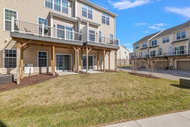 back of property featuring central air condition unit, a lawn, and a residential view