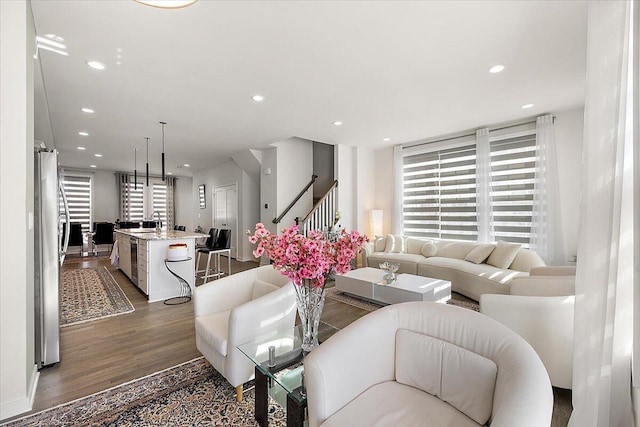 living area with dark wood-style flooring, recessed lighting, and stairway