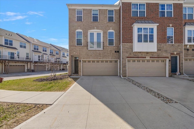 multi unit property featuring a residential view, an attached garage, brick siding, stone siding, and driveway
