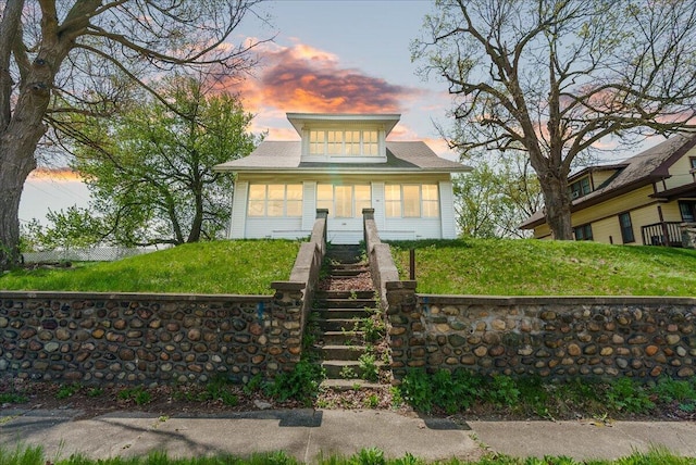 bungalow with stairs and a lawn