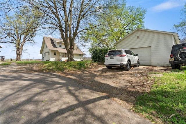 view of side of property featuring a detached garage and an outdoor structure