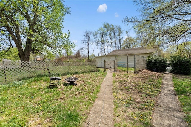 view of yard featuring fence, a gate, and a fire pit