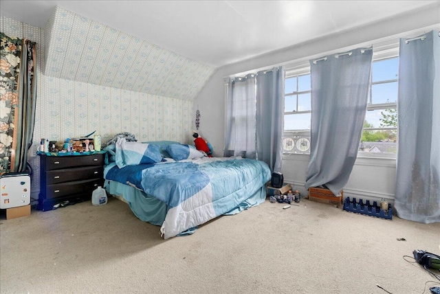 carpeted bedroom with vaulted ceiling and wallpapered walls