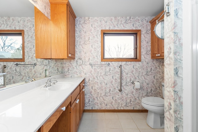 bathroom with toilet, baseboards, tile patterned flooring, and vanity