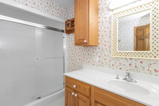 full bath with wallpapered walls, a shower stall, tile patterned flooring, and vanity