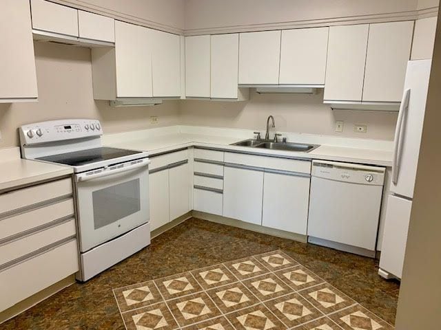 5000 Town Ctr Unit 706, Southfield, MI 48075 - kitchen featuring white appliances, a sink, white cabinetry, and light countertops