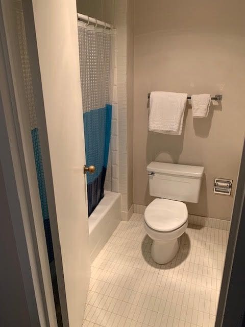 5000 Town Ctr Unit 706, Southfield, MI 48075 - bathroom featuring toilet, tile patterned floors, baseboards, and shower / tub combo with curtain