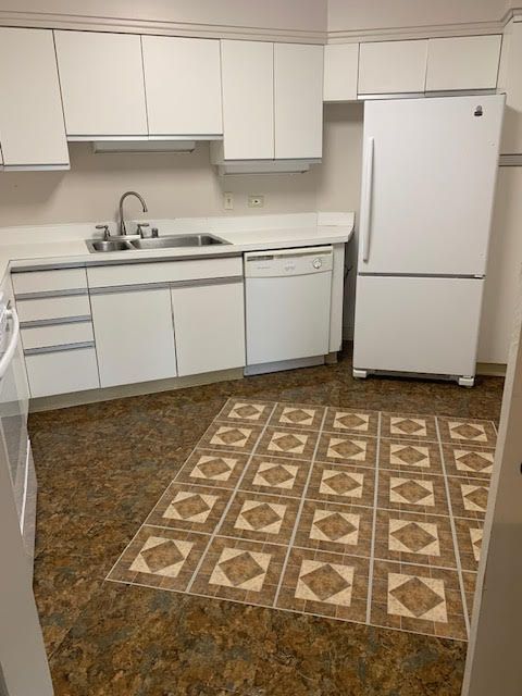5000 Town Ctr Unit 706, Southfield, MI 48075 - kitchen with white appliances, a sink, white cabinets, and light countertops