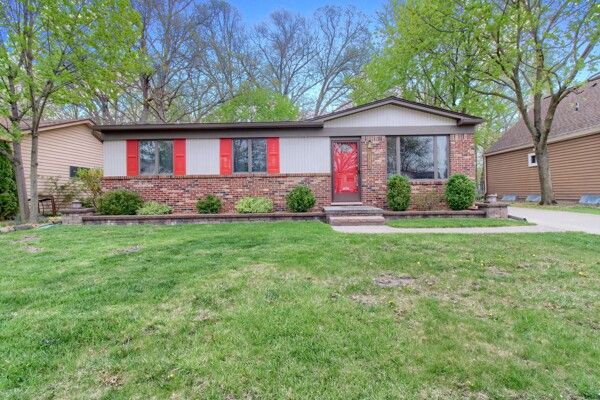 single story home with a front lawn and brick siding
