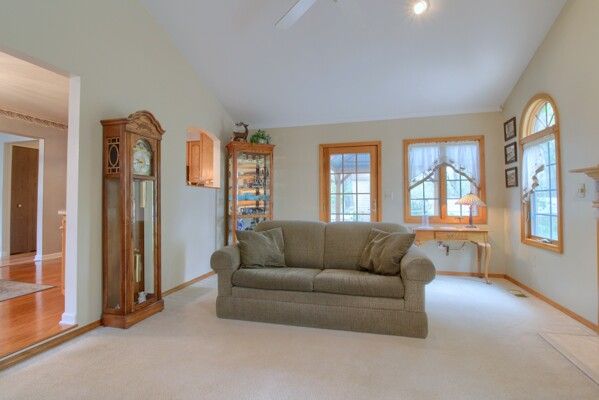 carpeted living area featuring plenty of natural light, baseboards, and vaulted ceiling