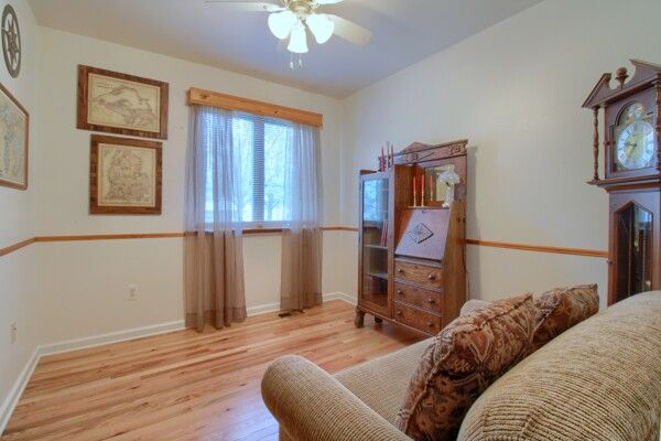 interior space featuring baseboards, a ceiling fan, and light wood-style flooring