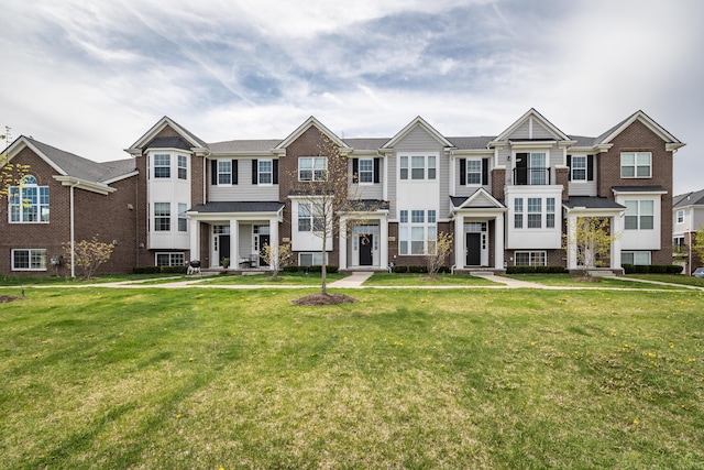 multi unit property with brick siding and a front lawn