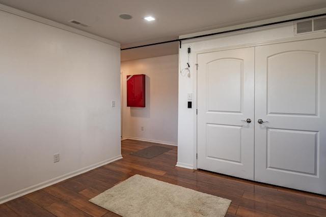 unfurnished bedroom with dark wood-type flooring, baseboards, and visible vents