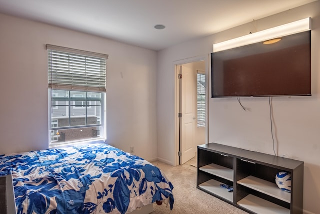 bedroom with baseboards and light carpet