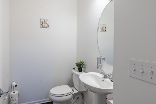 half bath featuring toilet and a sink