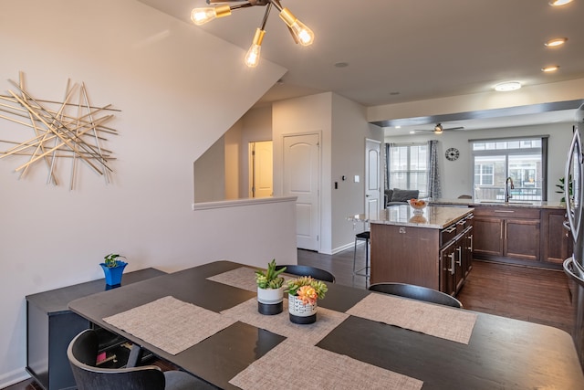 dining area with dark wood-style flooring, baseboards, recessed lighting, and a chandelier