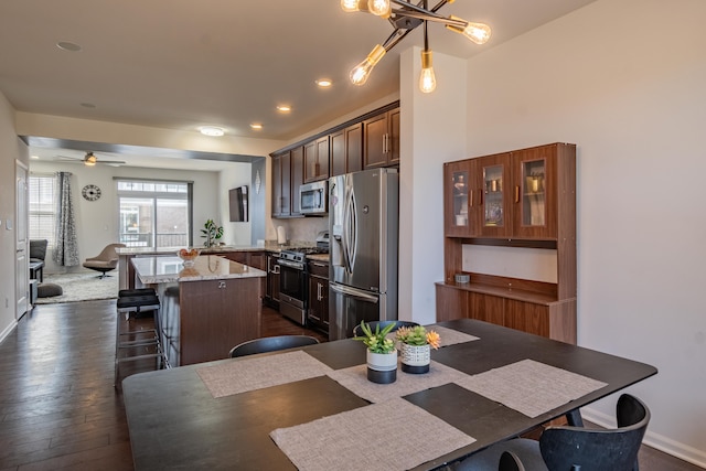 dining room with dark wood-type flooring, a ceiling fan, baseboards, and recessed lighting