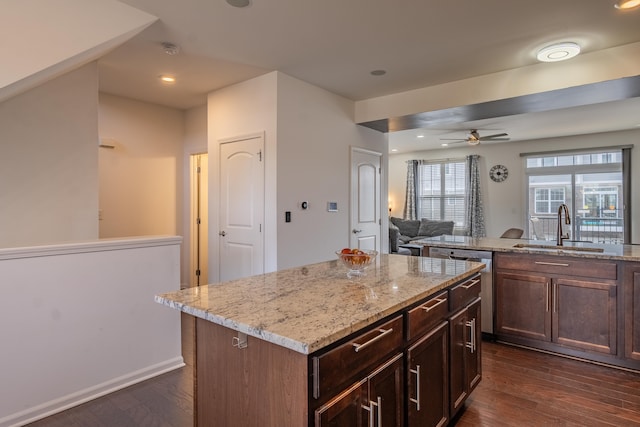 kitchen with a center island, a sink, dark wood-style flooring, and open floor plan