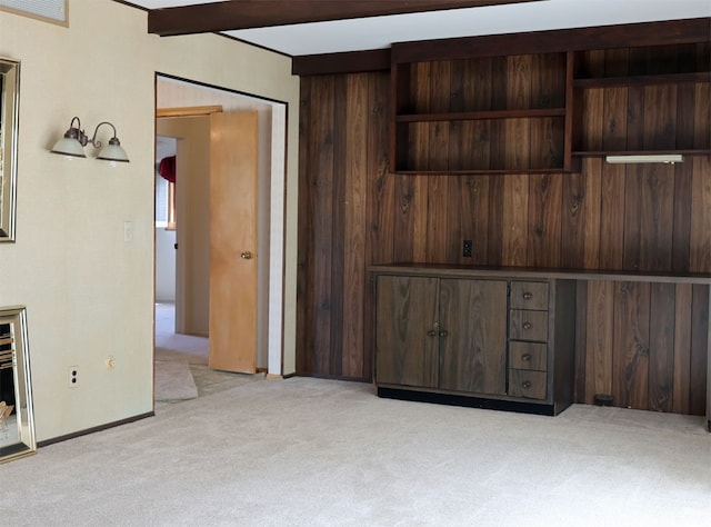 interior space featuring light colored carpet, baseboards, and beam ceiling