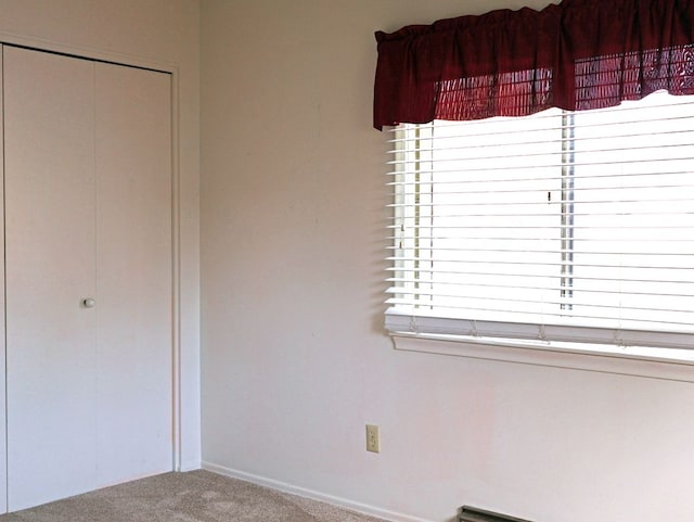 unfurnished room featuring carpet floors, baseboards, and a wealth of natural light
