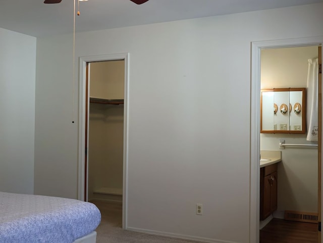 bedroom with a ceiling fan, connected bathroom, visible vents, a closet, and a spacious closet